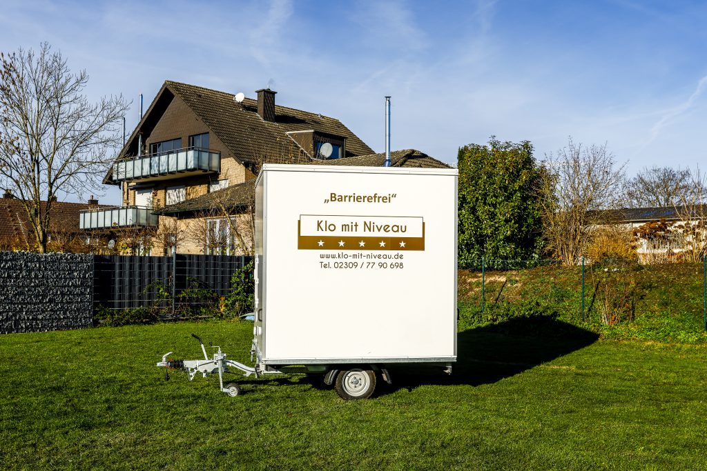 Außenansicht barrierefreier Toilettenwagen auf Achse stehend