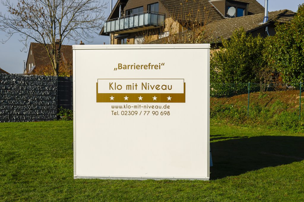 Außenansicht seitlich barrierefreier Toilettenwagen mit "Klo mit Niveau" Logo
